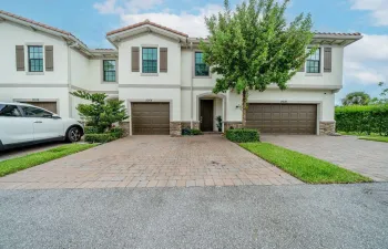 Mediterranean-inspired exterior with stucco finish, tile roof, and private driveway