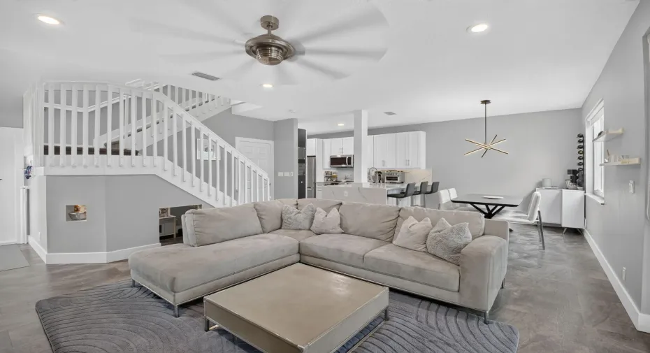 Oversized Great Room with impact windows, recessed lights, half bathroom, garage access, and renovated kitchen.