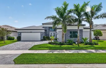 Striking architectural exterior with mature royal palm trees and lush landscaping.