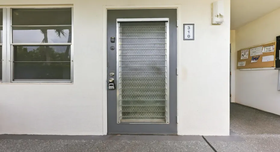 Welcoming exterior entry to this first-floor residence, offering convenient ground-level access and a covered approach to the front door.