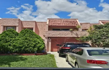 Stucco exterior with a tile roof accent, integrated garage, and a paved driveway