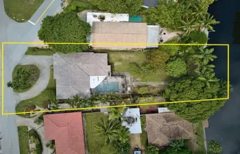 Overhead view illustrates the oversized lot extending from the street to the waterfront. Boundary lines are approximate.