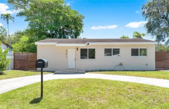 Classic street-facing view of 321 — a well-maintained ranch home with fresh exterior, updated windows, modern wood privacy fencing on both sides, and a generous green front yard.