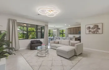 Open-concept living area with large windows, light tile flooring, and recessed lighting