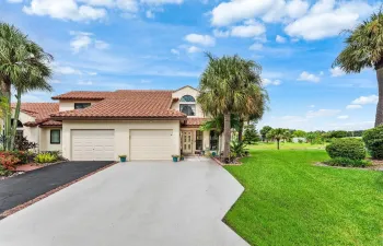 Mediterranean-style architecture featuring a tile roof, stucco exterior, and two-car garage