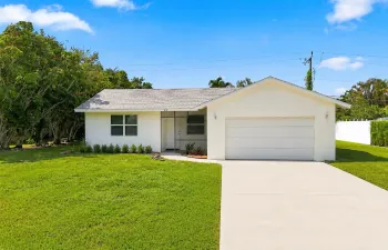 Front view of the home with attached garage, driveway, and lawn.