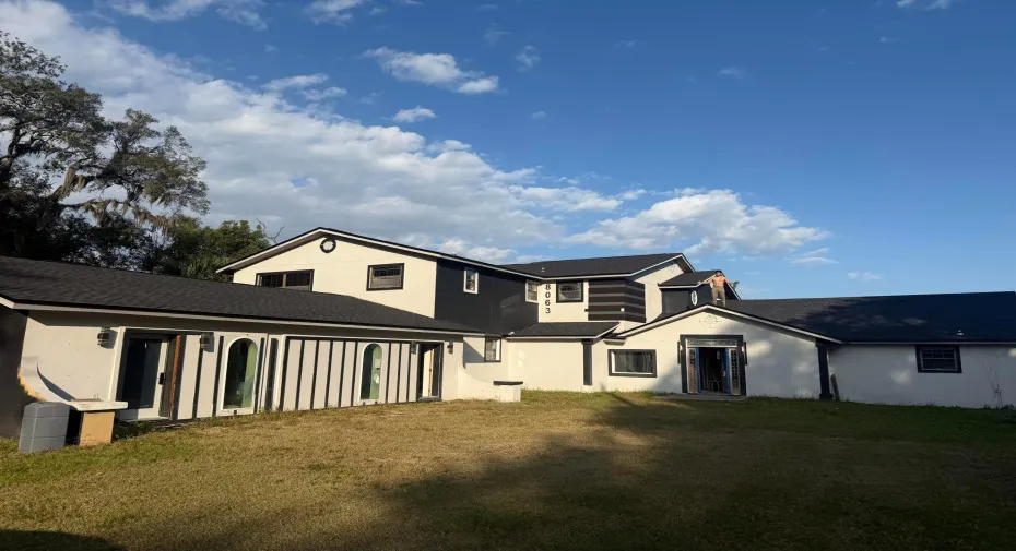 Multi-level exterior with a dark shingle roof and contrasting light and dark siding