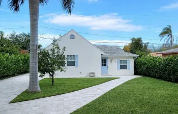 White stucco exterior with a gray shingle roof, blue shutters, and a matching blue entry​​‌​​​​‌​​‌‌​‌‌​​​‌‌​‌​‌​‌​​​‌​​ door
