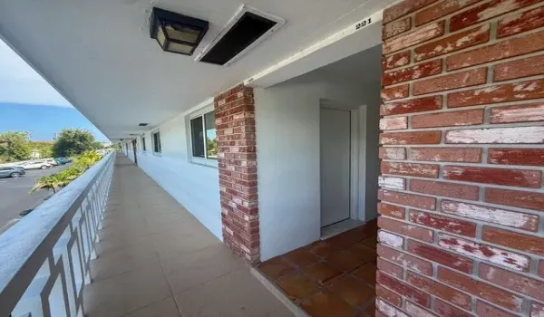 Brick exterior detailing, recessed lighting, and a white metal balcony railing
