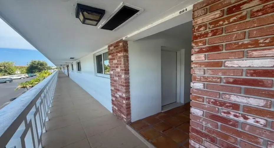 Brick exterior detailing, recessed lighting, and a white metal balcony railing
