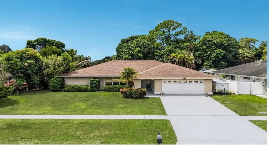 Single-story residence featuring a shingle roof, an attached two-car garage, and a concrete driveway