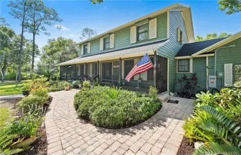Front of home with screened wrap around porch.