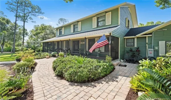 Front of home with screened wrap around porch.