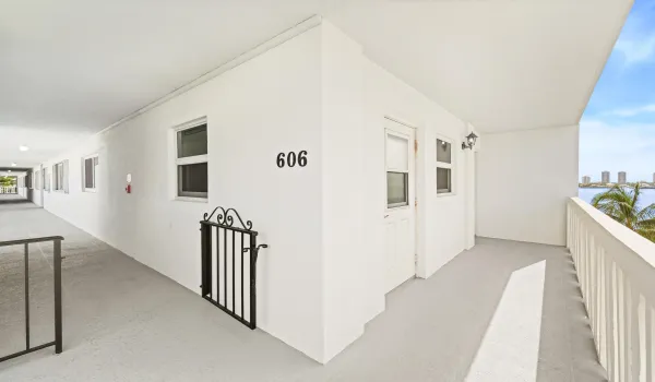 Open-air corridor with a private balcony featuring white railings