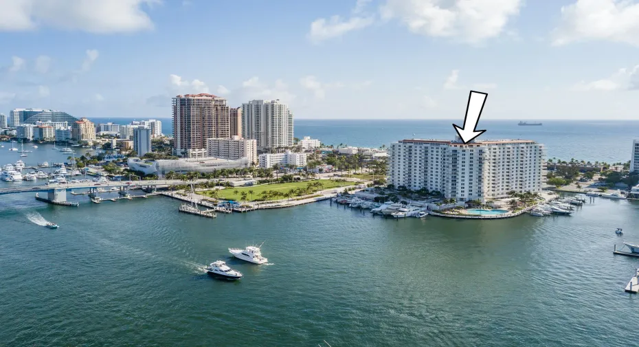 Waterfront high-rise building featuring a marina, outdoor swimming pool, and proximity to ocean and cityscape