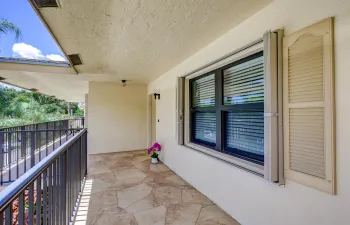 Exterior walkway featuring irregular cut tile flooring and wrought iron railings