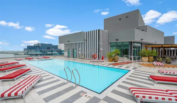 Rooftop pool with signature red-striped chaise lounges - elevated relaxation at SLS Brickell Dua.
