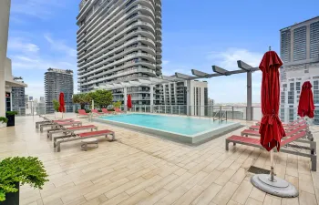 Rooftop terrace with a rectangular pool, surrounded by paver flooring