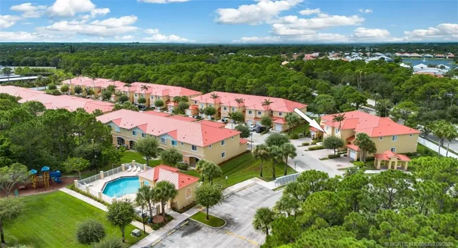 Townhouse with new metal roof is just a few steps from the community pool and is near the entrance of the community