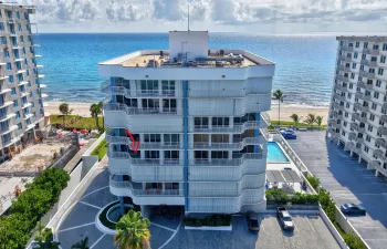 Coastal high-rise architecture with expansive balconies, a ground-level swimming pool, and direct beach access