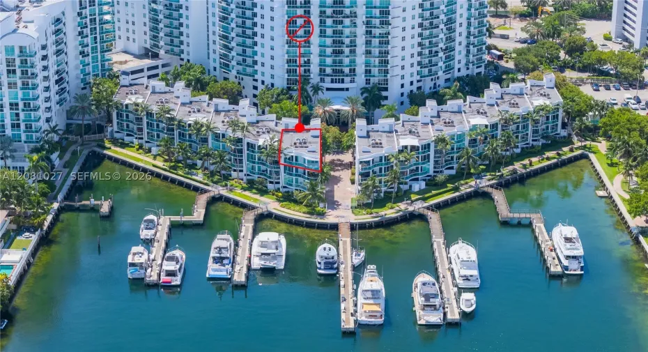 Center of marina, penthouse corner unit! Flyover view of building from the north with outline of unit.