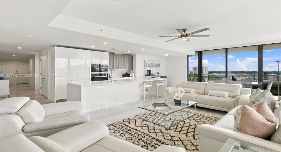 Spacious open-concept living room and kitchen with floor-to-ceiling glass.