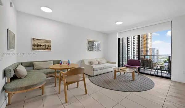 Living space featuring floor-to-ceiling glass sliding doors, private balcony, neutral tile flooring, and flush-mount lighting