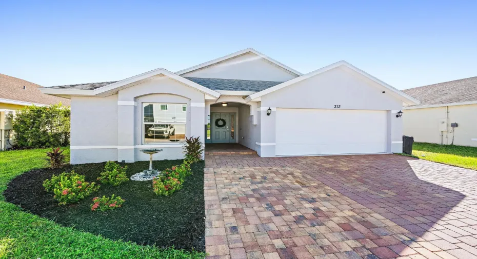 Curb appeal with paver driveway, 2-car garage and landscaped front yard