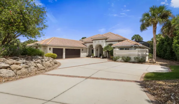 A grand welcome to 113 Island Estates Pkwy, where mature tropical landscaping and timeless architecture set the stage for the waterfront lifestyle waiting beyond the front door.