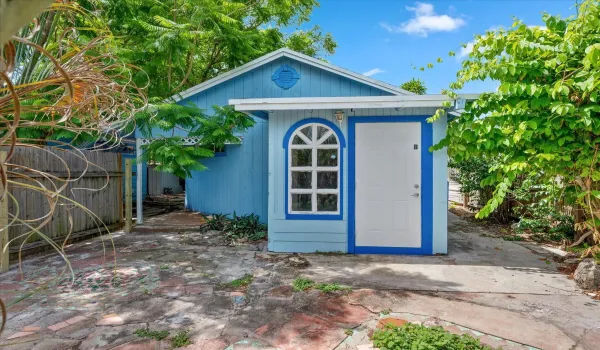 Blue exterior siding with white trim, arched window, and adjacent white door