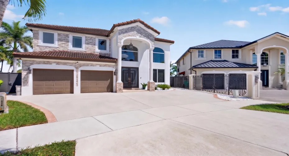 Two-car garage with a double-wide driveway plus gated side access for boat, trailer or RV parking.