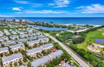 Aerial perspective showcasing a residential community, a water body, and a golf course