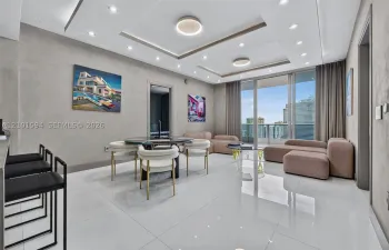 Epic Residences 50th-floor living and dining area with floor-to-ceiling glass and panoramic city views.