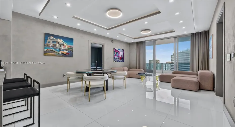 Epic Residences 50th-floor living and dining area with floor-to-ceiling glass and panoramic city views.
