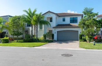 Mediterranean-style architecture with a tile roof, an arched entry, a two-car garage, and a paver driveway