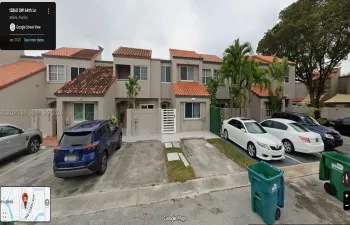 Two-story exterior featuring a clay tile roof, stucco facade, private gated courtyard entry, and dedicated concrete parking pads