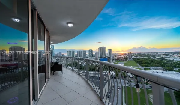 Expansive curved balcony featuring tiled flooring and a metal railing