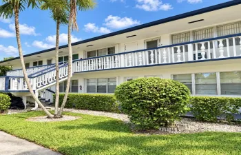 Two-story building featuring exterior walkways and stairs with decorative railings