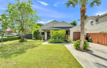 Single-story residence featuring a gabled roofline, front-facing attached garage, concrete driveway, and expansive lawn