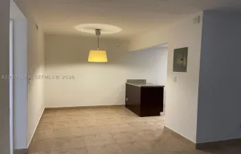 Tiled flooring, recessed ceiling light, pendant light fixture, built-in cabinetry with stone-finish countertop