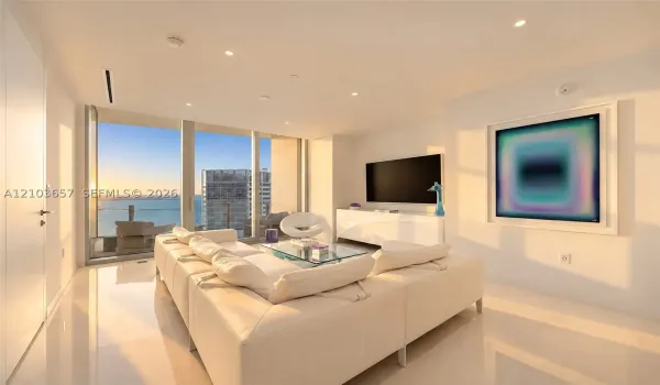 Expansive floor-to-ceiling windows, recessed lighting, sleek white tile flooring, and a built-in media console