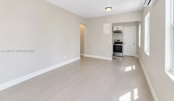 Open-concept living area featuring wood-finish flooring, recessed lighting, and ample natural light through multiple windows