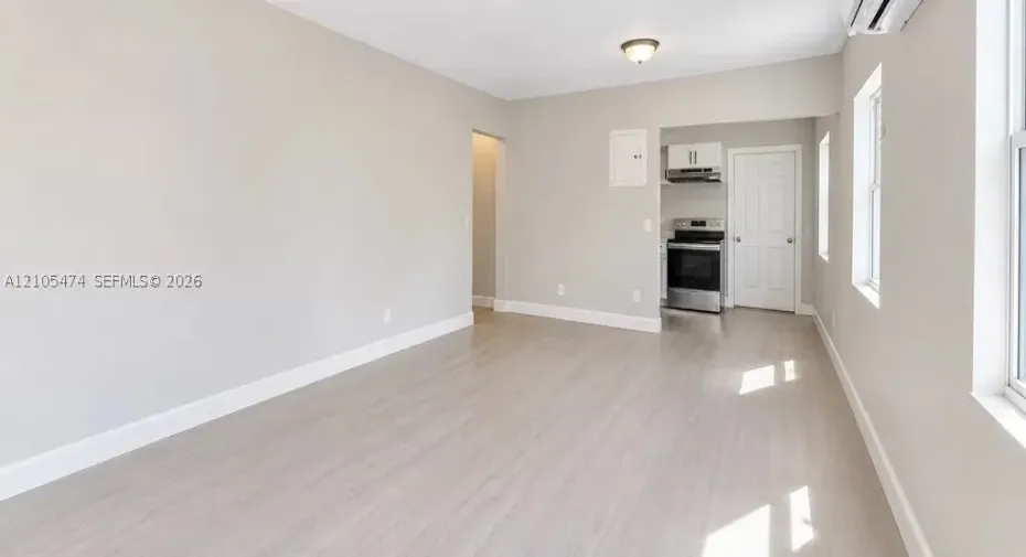 Open-concept living area featuring wood-finish flooring, recessed lighting, and ample natural light through multiple windows