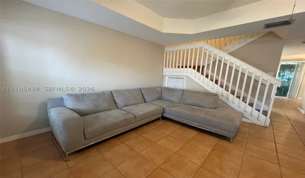 Staircase with white balusters and wood treads, accented by a built-in storage compartment