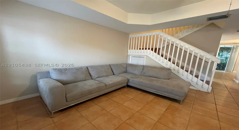 Staircase with white balusters and wood treads, accented by a built-in storage compartment