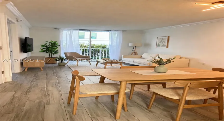 Open concept living space featuring wood-finish flooring, sliding glass doors to a balcony, and a contemporary ceiling light fixture