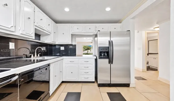 White cabinetry paired with dark countertops and a coordinating tile backsplash