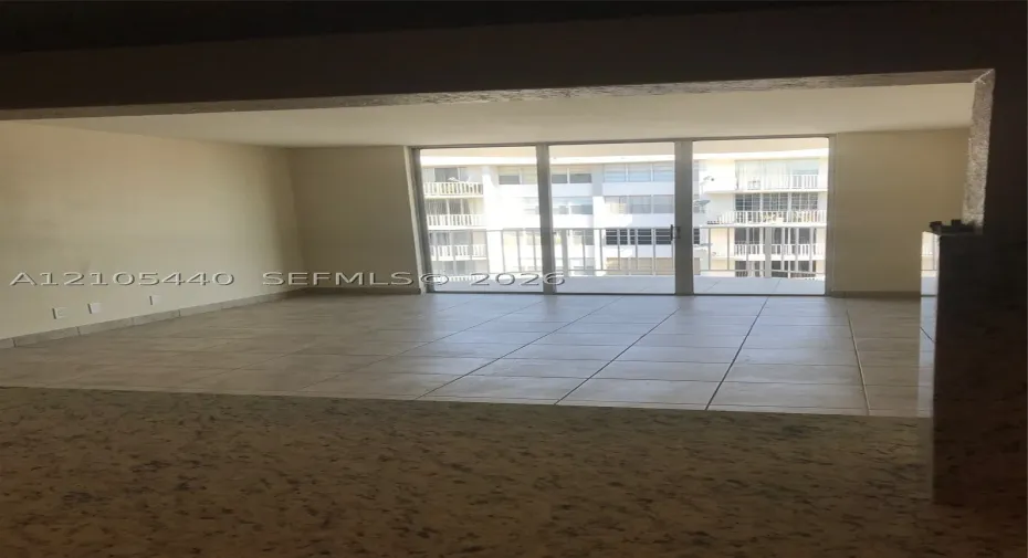 Expansive living space featuring light-toned tile flooring and neutral wall finishes