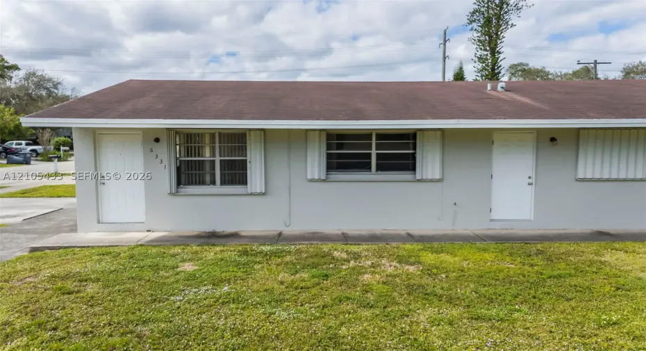 Light gray stucco exterior with two white entry doors