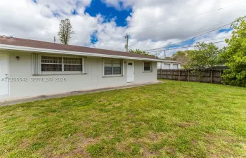 Expansive yard with mature landscaping and a wood fence